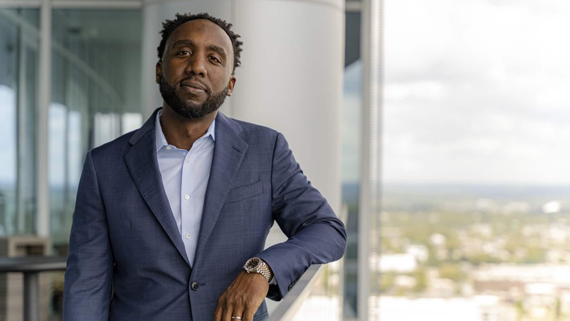 C.J. Spiller In A Suit Standing In Front Of A Window