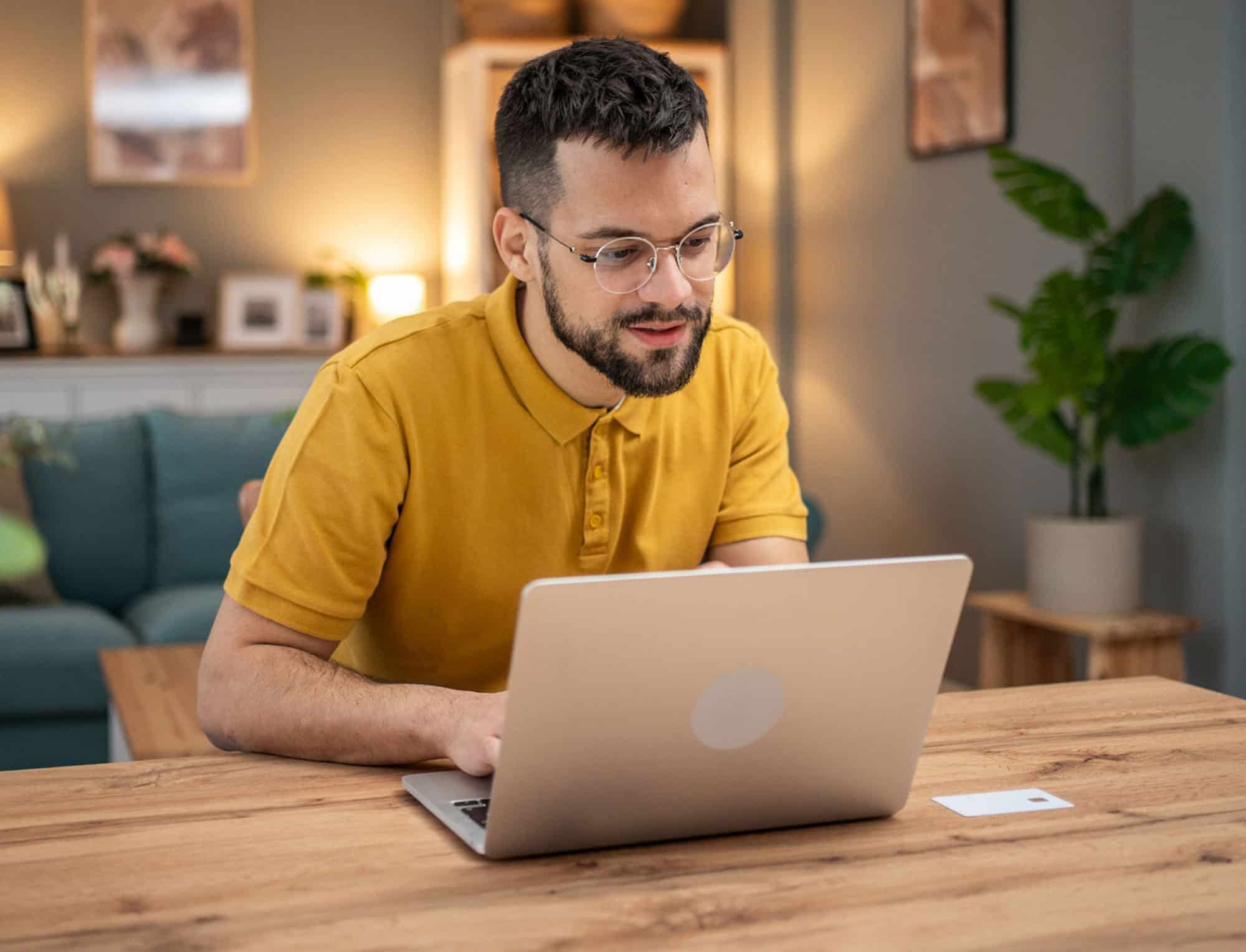 a man sitting at a table using a laptop computer