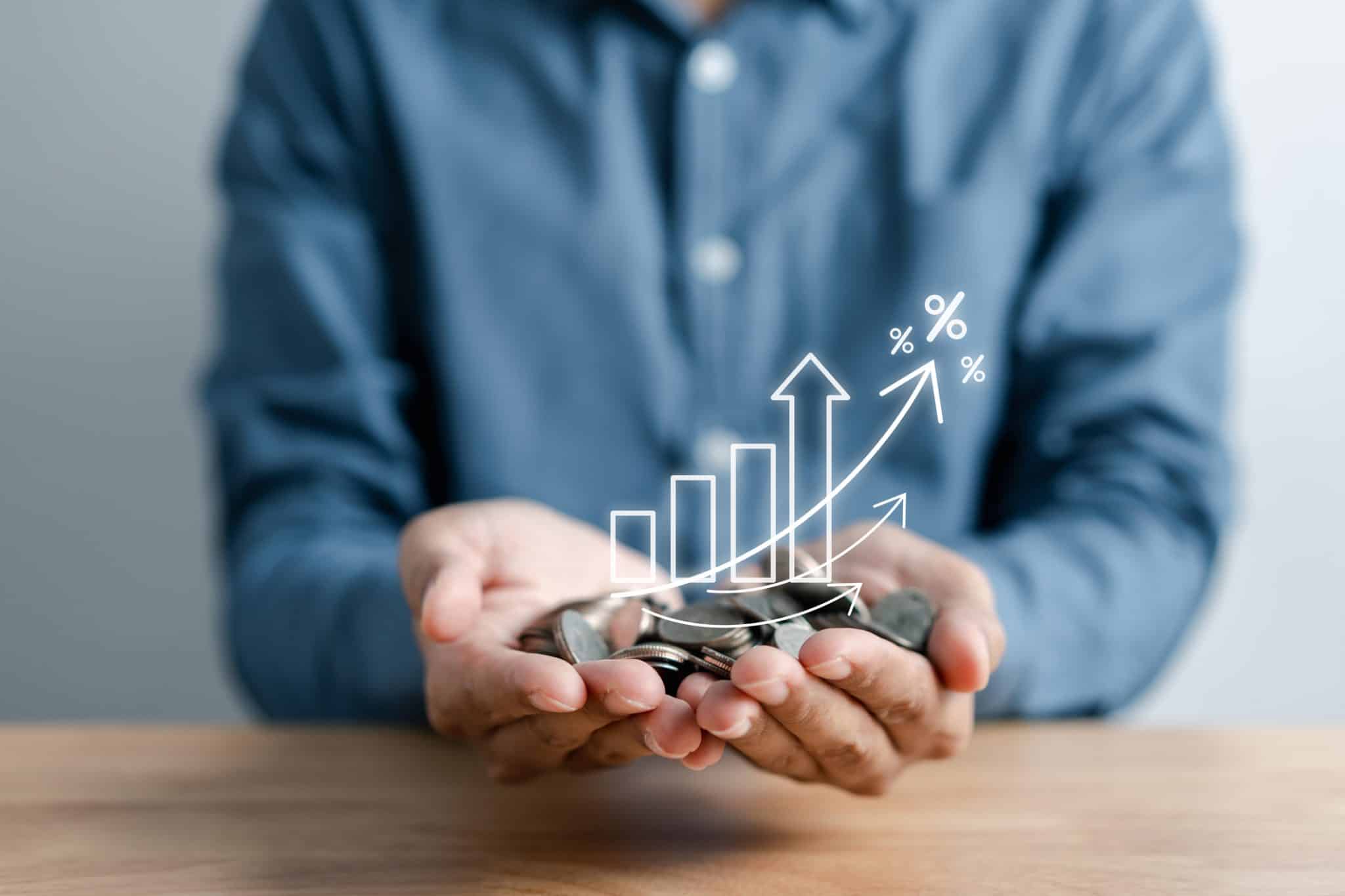 Man holding money in his hand with symbols representing growth in interest-bearing business accounts.