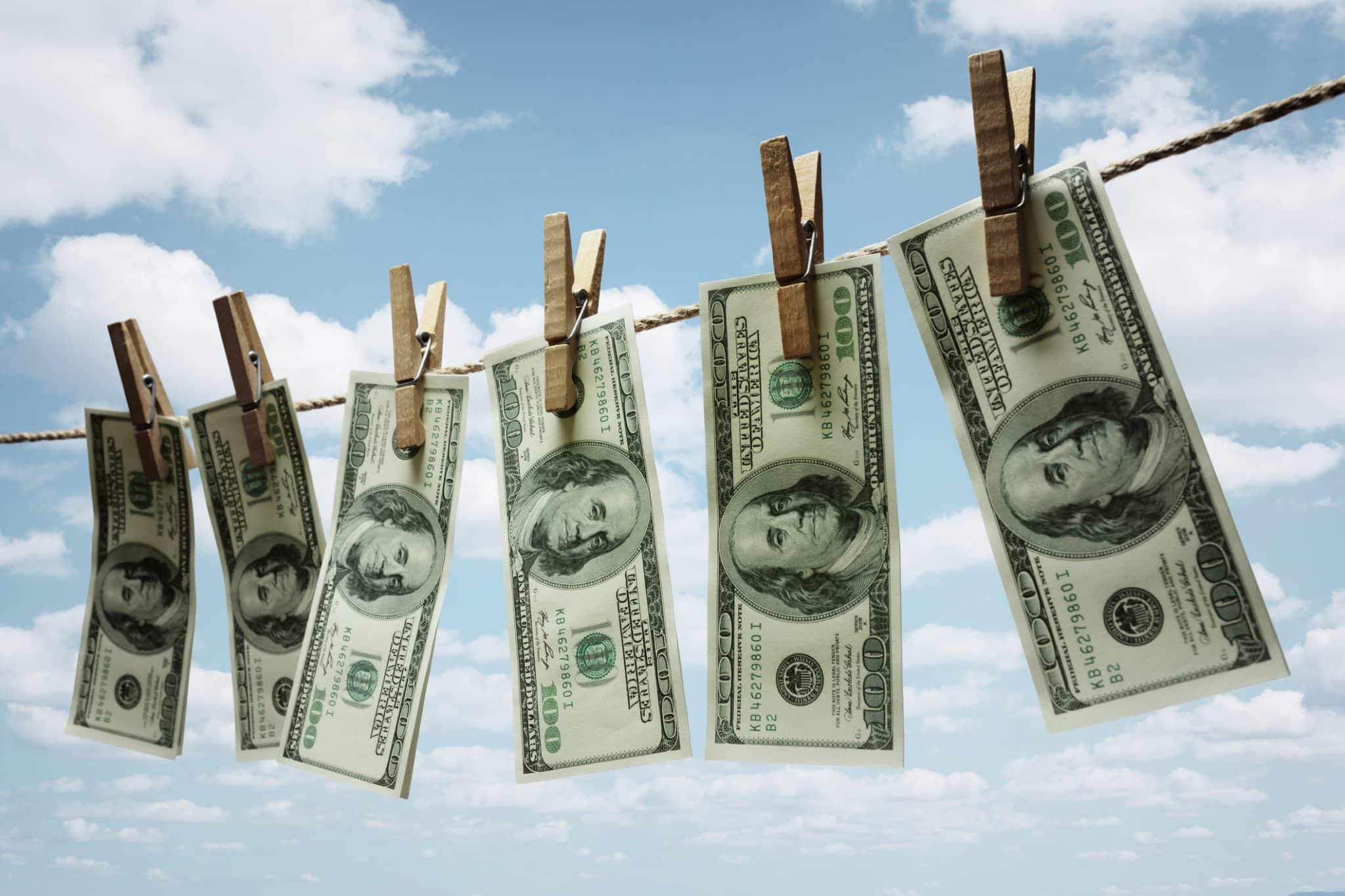 Money hanging out to dry on a line, referencing some personal finance spring cleaning tips for Nashville residents.