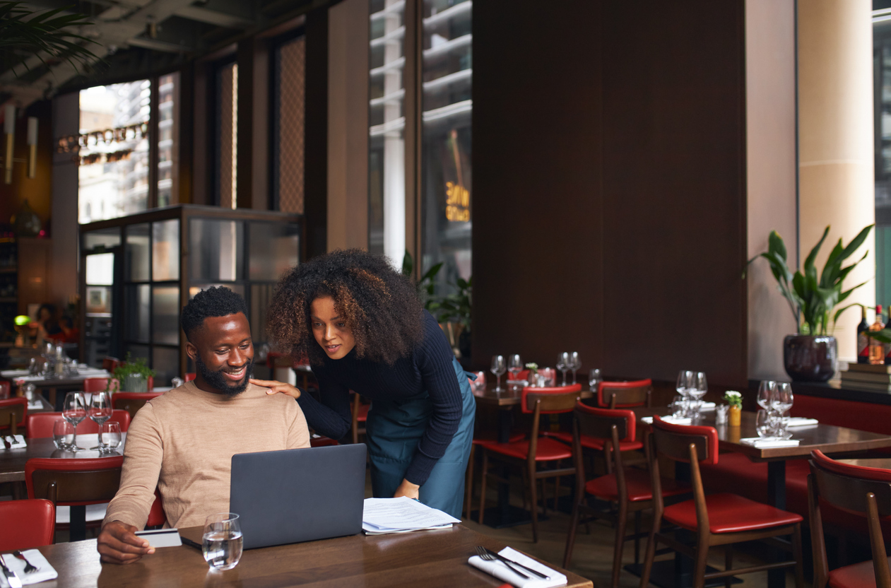 Small business owners managing cash flow on a laptop, a sign it may be time to upgrade to better business banking solutions.